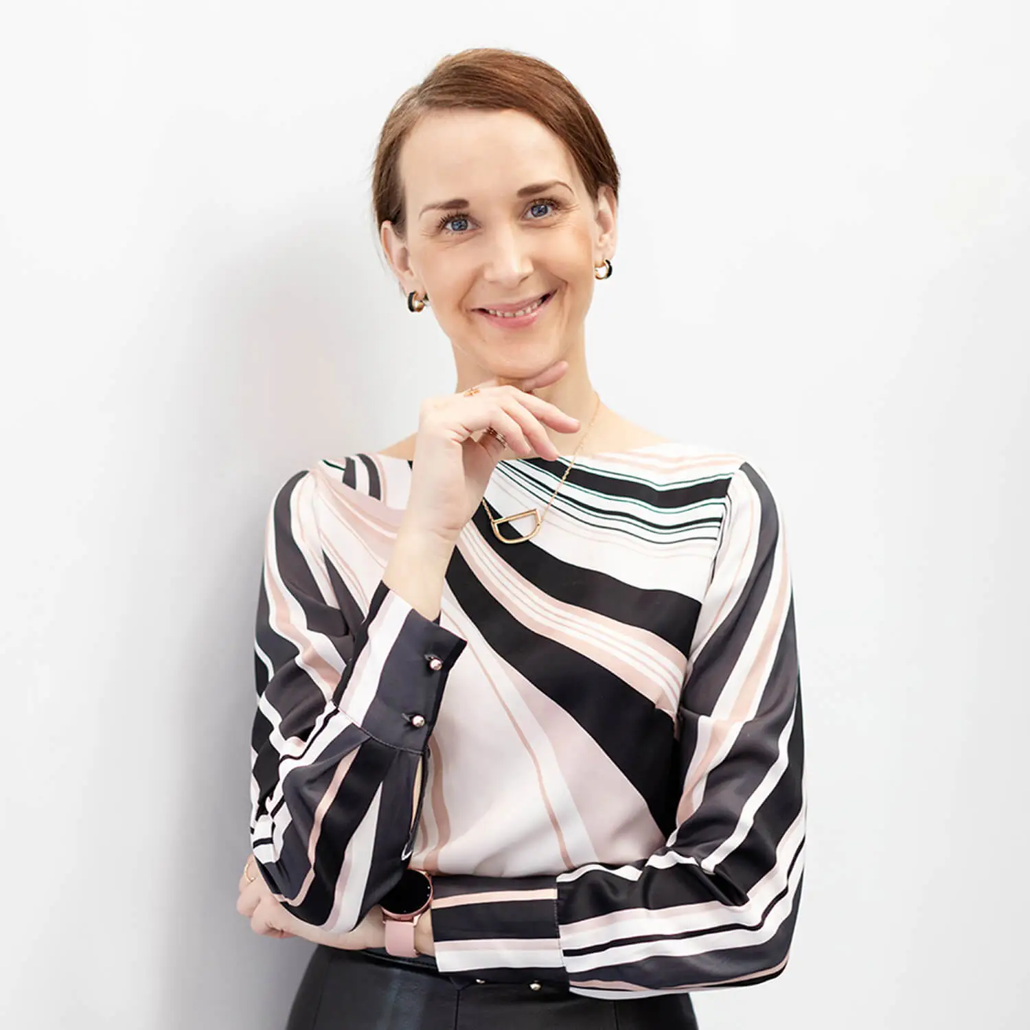 Success and Business Coach Dijana Llugolli wearing a smart striped, silky top